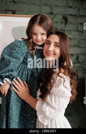 Giorno della mamma. Giovane mamma sensibile abbraccia a casa sua piccola adorabile figlia. Fiducia, sostegno e amore tra mamma e bambino. Amiamo la famiglia godere Foto Stock