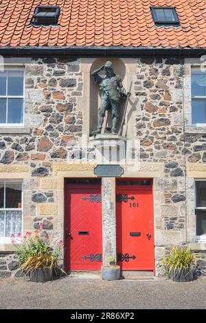 Lower Largo, Regno Unito - 9 giugno 2023: Una statua di Robinson Crusoe in un recinto recinto muro enclave o nicchia nel villaggio natale di Alexander Selkirk, a Fife, S Foto Stock