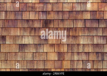 Ghiaia di cedro naturale siding.Rough Bumpy legno shingle cladding, fila di materiale di legno di piccole pareti shingle facade.Shingle rosso legno di cedro scuotere fila siding pannello tetto fatto di larice conifere Foto Stock