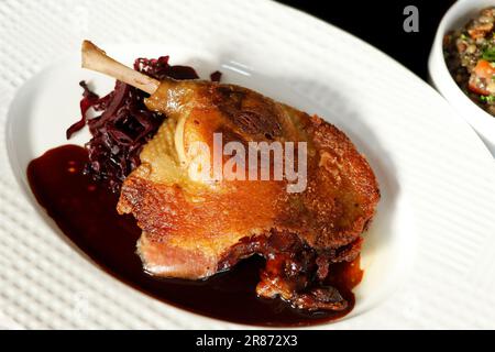 tradizionale confit francese croccante pelle su gamba d'anatra con cavolo rosso brasato Foto Stock