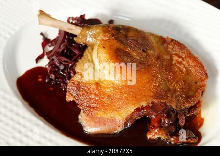 tradizionale confit francese croccante pelle su gamba d'anatra con cavolo rosso brasato Foto Stock