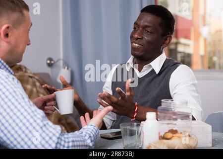 Allegro africano che parla con un amico a casa Foto Stock