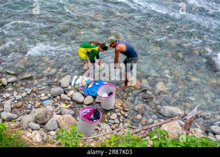 Provincia occidentale di Mindoro, Filippine - 10 giugno 2023. Un uomo e una donna filippini lavano a mano in un fiume sull'isola di Mindoro. Foto Stock