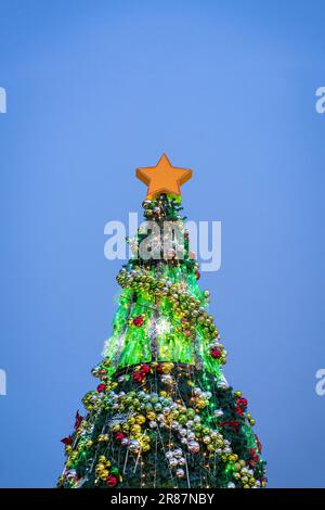 Albero di Natale splendidamente decorato illuminato, con sfondo cielo blu sera. Spazio di copia. Foto Stock