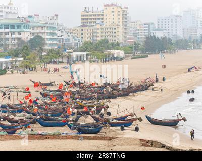 Le tradizionali barche vietnamite da pesca hanno spiaggiato in una giornata fosca a Sam Son Beach, nella provincia di Thanh Hoa, in Vietnam. Alberghi e resort lungo la spiaggia v Foto Stock