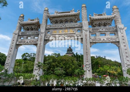 Porta di montagna (San Men) ingresso al Monastero di po Lin con il Grande Buddha, (Tian Tan) sopra la linea degli alberi, Villaggio di Ngong Ping, Lantau, Hong Kong, C. Foto Stock