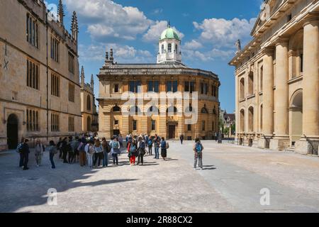 Turisti sul Quad Sheldonian con il Teatro Sheldonian, Divinity School sulla sinistra, Clarendon Building sulla destra, Oxford, Oxfordshire Foto Stock