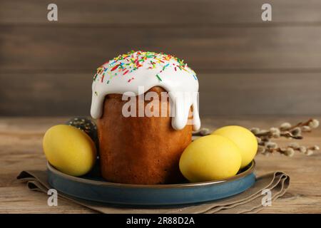 Gustosa torta di Pasqua, uova decorate e rami di salice su tavola di legno Foto Stock