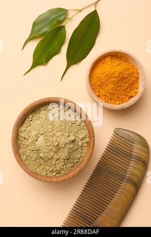 Composizione a posa piatta con henné e polvere di curcuma su fondo beige. Colorazione naturale dei capelli Foto Stock