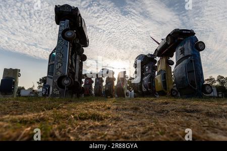 Foto dell'handout non pubblicata da Carhenge Glastobury dell'installazione di Carhenge dell'artista Joe Rush, sul sito del Festival di Glastonbury presso la Worthy Farm di Somerset. Composta da 24 auto d'epoca erette al centro del festival, l'installazione emula l'antica struttura in pietra di Stonehenge. Data di emissione: Martedì 20 giugno 2023. Foto Stock