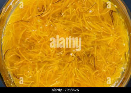 Confettura dolce in vaso di vetro confettura da petali gialli maturi di fiori di dente di leone, arancia, limone e zucchero, vista dall'alto, primo piano. Dente di leone famosa pianta medicinale Foto Stock