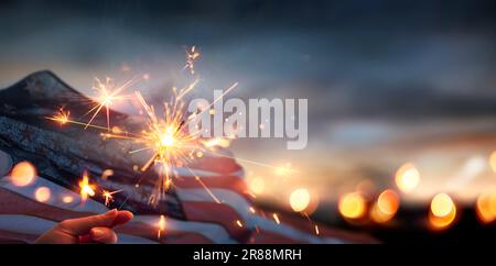 Bandiera americana con Sparkler - 4th luglio - giorno dell'Indipendenza e Memorial Day - luci defocate astratto Foto Stock