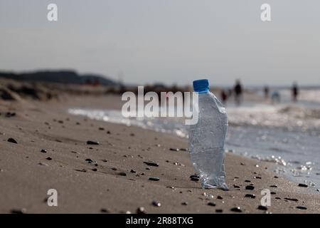 Bottiglia d'acqua in plastica PET abbandonata. Il concetto di "cucire" l'ambiente naturale. Danni ecologici sulla spiaggia Foto Stock