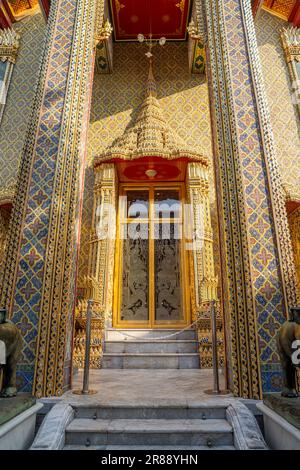 Una porta decorativa d'oro per la sala delle ordinazioni o Ubosot a Wat Ratchabophit Sathitmahasimaram Ratchaworawihan a Bangkok, Thailandia. Foto Stock