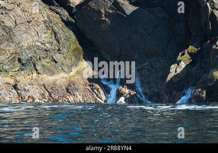 norvegia sul fiordo, spruzzare sulle rocce. Spruzzi d'acqua sulle pietre. Paesaggio costiero in Scandinavia. Foto del paesaggio da nord Foto Stock