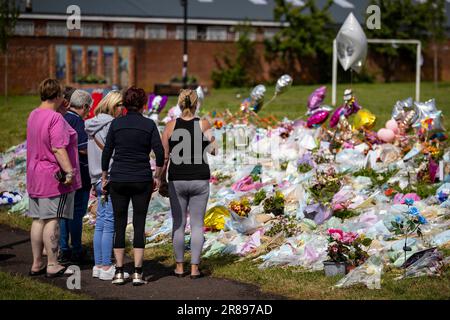 La gente guarda i tributi floreali al King George's Park ad Harryville, Ballymena, in ricordo di Chloe Mitchell. Ryan Johnston Gordon, 34 anni, da Nursery Close, Ballymena, è apparso tramite video link dal carcere di Maghaberry incaricato di assistere un delinquente per la morte di Chloe, 21 anni, che è stato visto l'ultima volta nelle prime ore di Sabato 3 giugno nel centro di Ballymena. Data immagine: Martedì 20 giugno 2023. Foto Stock