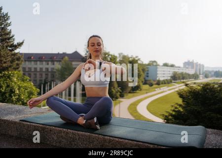 Giovane donna sportiva che controlla le sue prestazioni sullo smartwach dopo la sessione di allenamento. Foto Stock