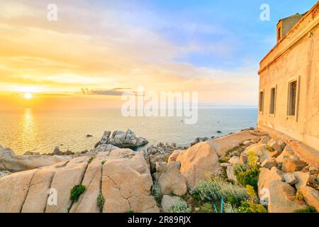 L'antico faro al tramonto sulla penisola di Capo testa, Sardegna, Italia Foto Stock