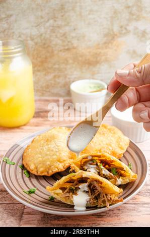 Cibo tradizionale venezuelano con guasacas. Sfondo rustico e di legno Foto Stock