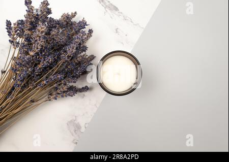 Vista dall'alto dei fiori di lavanda su sfondo di marmo grigio e bianco. Bouquet di lavanda, giacitura piatta di candela. Spazio di copia. Foto Stock