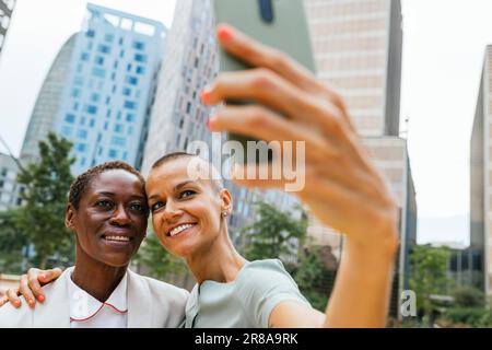 Donne d'affari che scattano selfie con un telefono cellulare Foto Stock