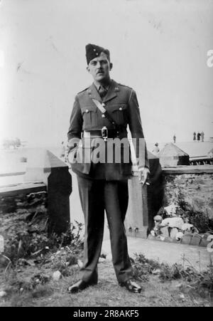 Un capitano R.A.F. in uniforme fumando una sigaretta in un giardino, c1941. Da una raccolta di fotografie personali, molte delle quali non sono state annotate in alcun dettaglio. La famiglia senza nome era di Witley, un piccolo villaggio di Waverley e vicino a Godalming nel Surrey, Inghilterra. Foto Stock