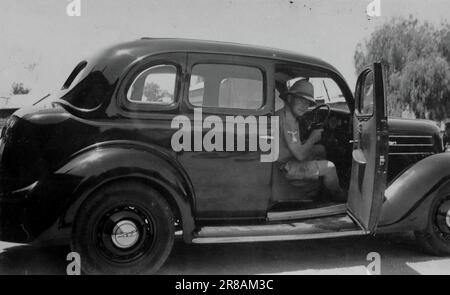 Un serviceman in uniforme, creduto essere a R.A.F. Heany in Bulawayo (Rhodesia, ora conosciuta come Zimbabwe), c1942, in quella che si pensa sia una Ford V8 auto a motore. Da una raccolta di fotografie personali, molte delle quali non sono state annotate in alcun dettaglio. La famiglia senza nome era di Witley, un piccolo villaggio di Waverley e vicino a Godalming nel Surrey, Inghilterra. Foto Stock