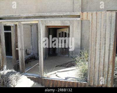 Porta d'ingresso di una casa abbandonata in una città fantasma chiamata Kolmanskop, situata vicino a Luderitz in Namibia Foto Stock