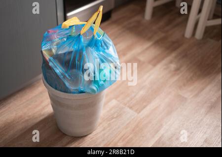 Cestino pieno della spazzatura in un sacchetto della spazzatura con le corde possono levarsi in piedi alla stanza Foto Stock