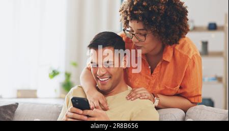 Scherzo sui social media, telefono e coppia felice sul divano con sorriso, risata e ricordo Internet in appartamento. Felicità, uomo e donna sul divano in soggiorno Foto Stock