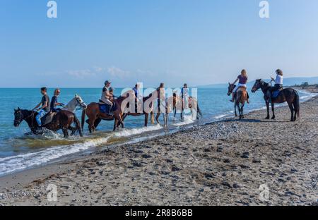 Policoro, Italia - 7 maggio 2023: Persone a cavallo in una spiaggia di Policoro, Basilicata, Italia meridionale. Foto Stock