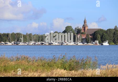 Vista sul pittoresco lago Vattern, verso la chiesa Askersund e il porticciolo nella contea di Orebro in Svezia. Giorno di sole estati, con cielo blu. Spazio di copia Foto Stock