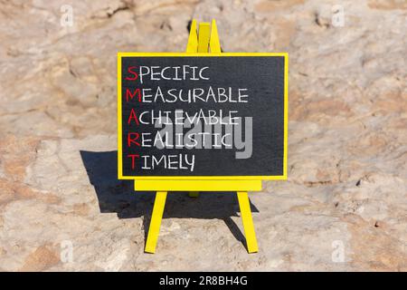 SIMBOLO SMART. Concetto di parole SMART specifico misurabile realistico realizzabile tempestivo sulla lavagna. Splendido sfondo in pietra. Specifico business SMART m Foto Stock