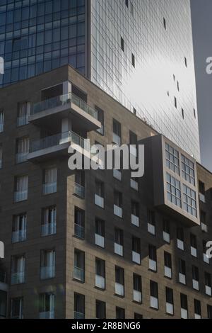 Facciata di un moderno edificio in mattoni nella sua parte inferiore e una parte sopra di esso con recinzione in vetro. Immobiliare Foto Stock