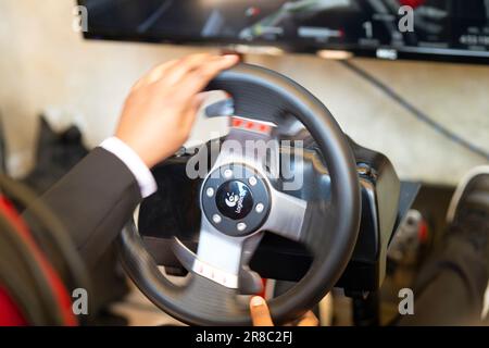 Mani di un uomo su un volante, mentre gioca un gioco di corse Foto Stock