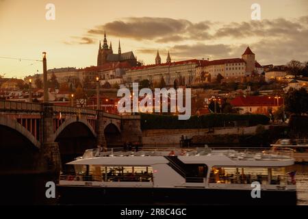 Paesaggio con San Cattedrale di Vito e barca al tramonto in autunno a Praga, Repubblica Ceca. Foto Stock