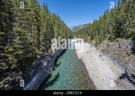 Il fiume Glacial Cascade che scorre sotto il ponte Stewart Canyon al lago Minnewanka, Banff, Alberta, Canada Foto Stock