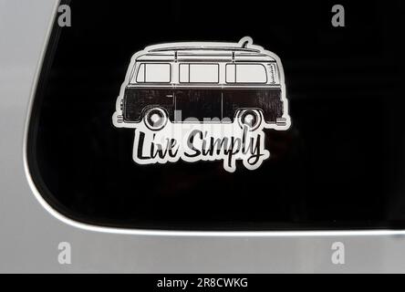 Un adesivo o una decalcomania in vinile "Live Simply" realizzata con un'immagine di un autobus Volkswagen apposta su un finestrino di un'auto parcheggiata ad Abingdon, Virginia. Foto Stock