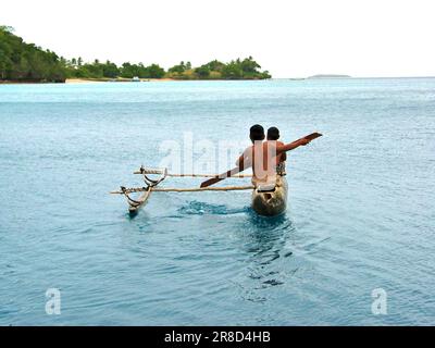 I bambini che paddling in una canoa, due giovani Tongani in un dugout proa. Foto Stock