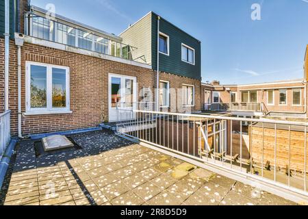 l'esterno di una casa con pareti in mattoni e rifiniture bianche intorno alle ringhiere, finestre e porte del balcone Foto Stock