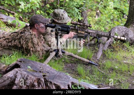 Una delle abilità più importanti di cui un cecchino ha bisogno è la capacità di colpire il proprio obiettivo senza essere visto. I soldati con la truppa di Charlie, 1st Squadrone, 172nd reggimento di cavalleria, 86th squadra di combattimento della Brigata di Fanteria (montagna), la Guardia Nazionale dell'Esercito del Vermont, esercitano le loro abilità sulla High Angle Range durante l'allenamento annuale al campo di fuoco di Ethan Allen a Gerico, Vermont, giugno 14. Foto Stock