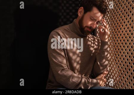 Sconvolgente l'uomo che ascolta il sacerdote durante la confessione in cabina, spazio per il testo Foto Stock