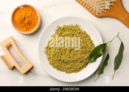 Composizione piana con henné e polvere di curcuma su tavola di marmo bianco. Colorazione naturale dei capelli Foto Stock