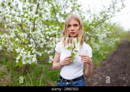 Ritratto di una donna che tiene un ramo di mele nel frutteto Foto Stock