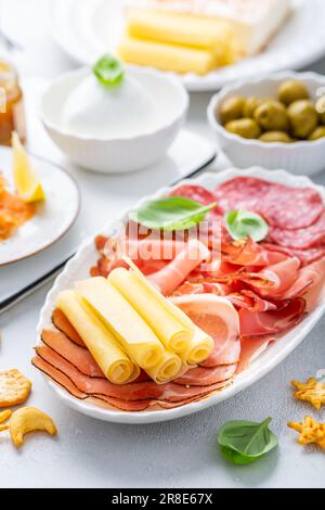 Antipasti con diversi antipasti, salumi, spuntini, piatto di carne con formaggio e olive speziate, carpaccio di salmone e insalata di pomodoro Foto Stock