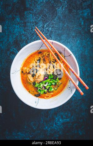 Zuppa di curry rosso tailandese con pollo, funghi shiitake, latte di cocco e cipolle verdi Foto Stock