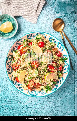 Insalata di tabbouleh, tradizionale mediorientale e piatto arabo. Insalata vegetariana Levantine con prezzemolo, menta, bulgur, pomodoro e cetriolo Foto Stock