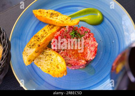 Tartare di vitello fresco servito con bruschette Foto Stock