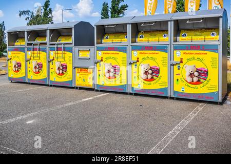 Hockenheim, Germania - 18 giugno 2023: Nuova collezione moderna di bidoni gialli per la donazione di abiti e scarpe in beneficenza. Traduzione: Utilizzo in Unione, per gli ambientisti Foto Stock