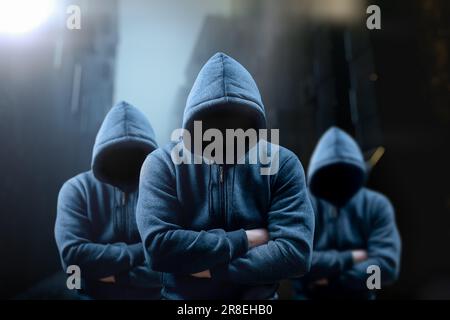 Criminale pericoloso. Silhouette di banditi, criminali con un volto irriconoscibile in posa minacciosa di notte su strada oscura. Spaventoso pericoloso si Foto Stock